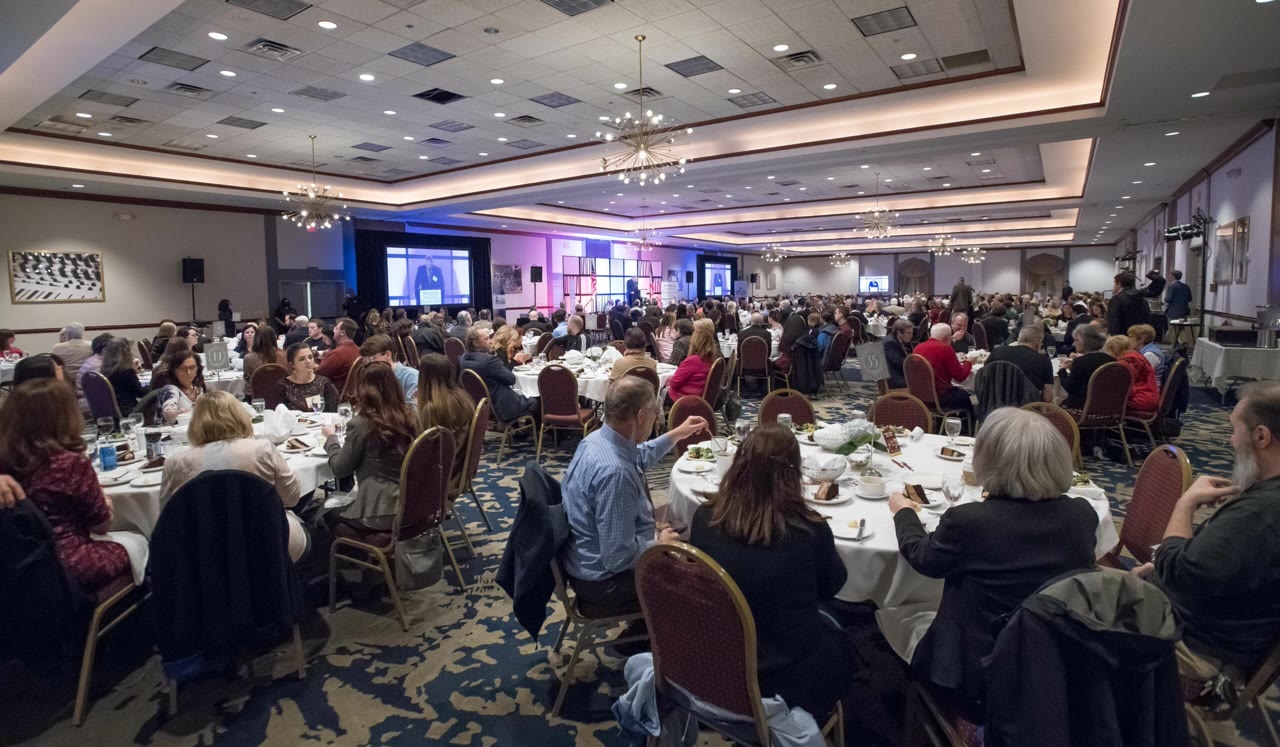Wide view of an elegant ballroom setup with round tables and sophisticated lighting, representing the professional conference venues that this nonprofit organization manages through their streamlined registration system.
